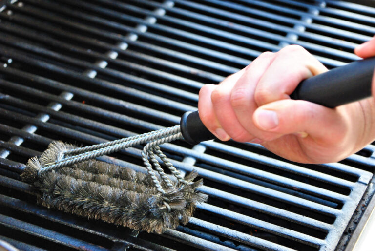 A close-up picture of a BBQ grill being cleaned.