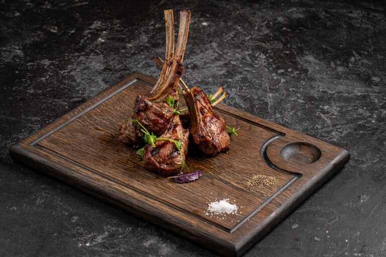 A Grilled rack of lamb on a chopping board
