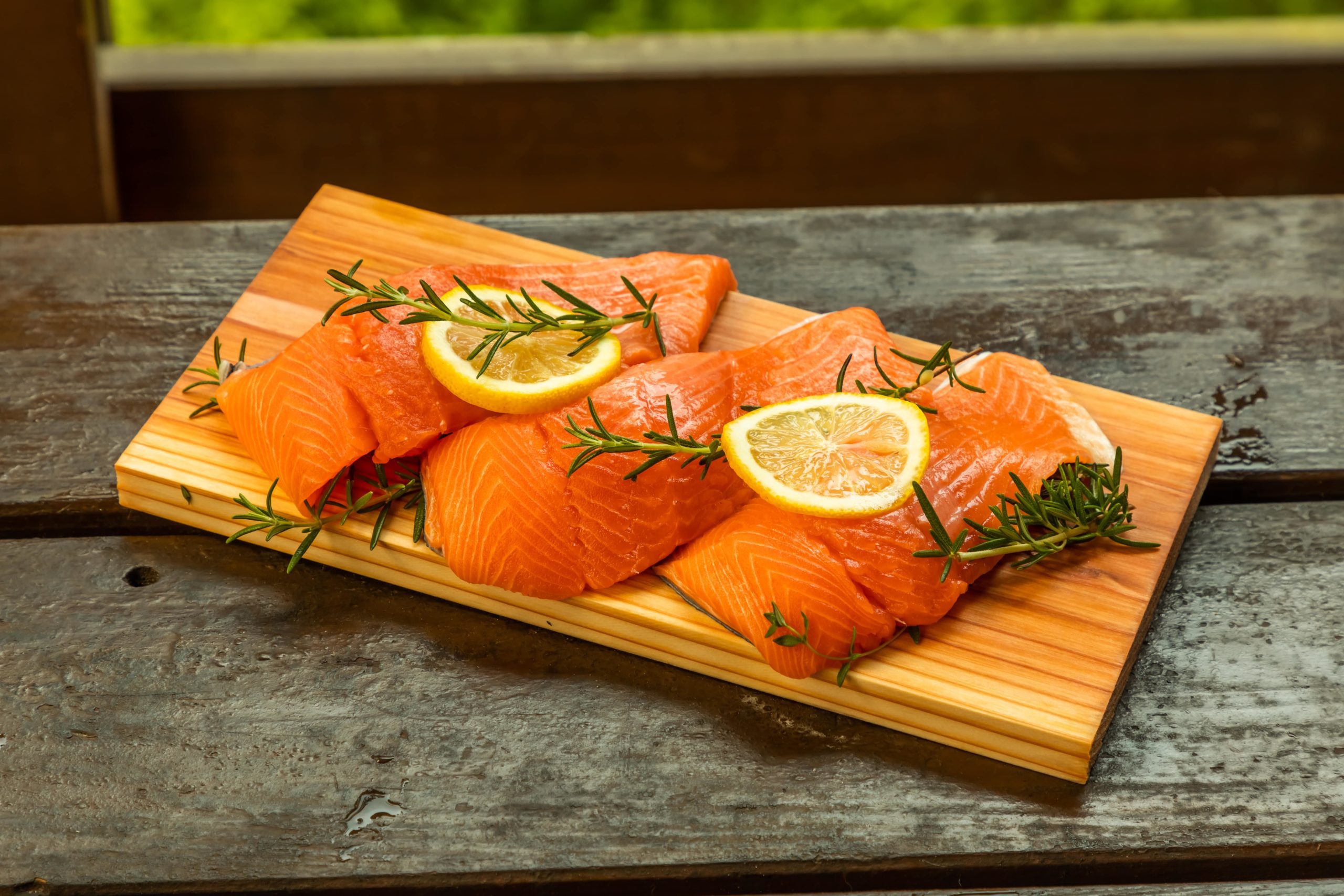 wood plank barbecue set with fresh salmon and lemon