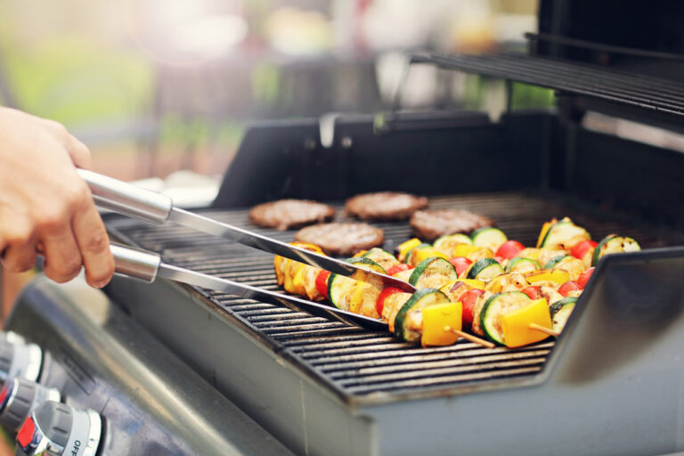 A picture of food being placed on a BBQ