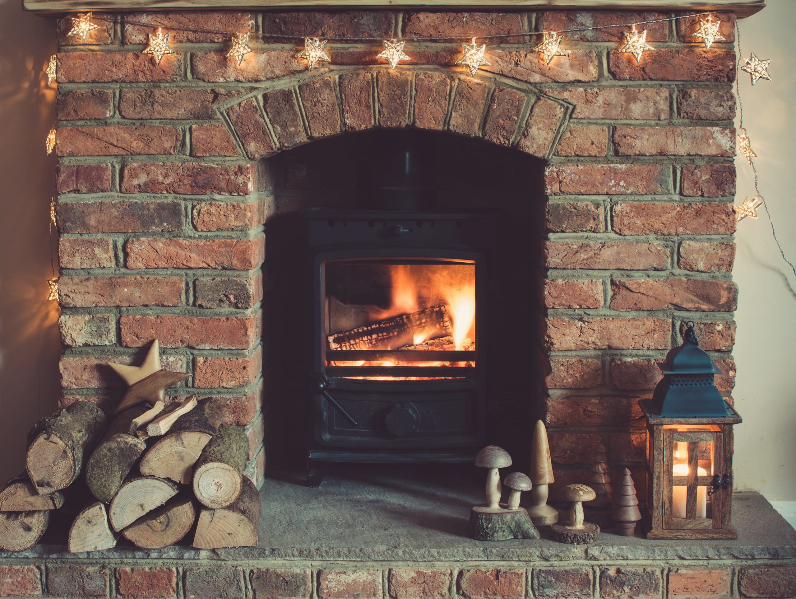 Log burner fireplace with burning logs on open fire