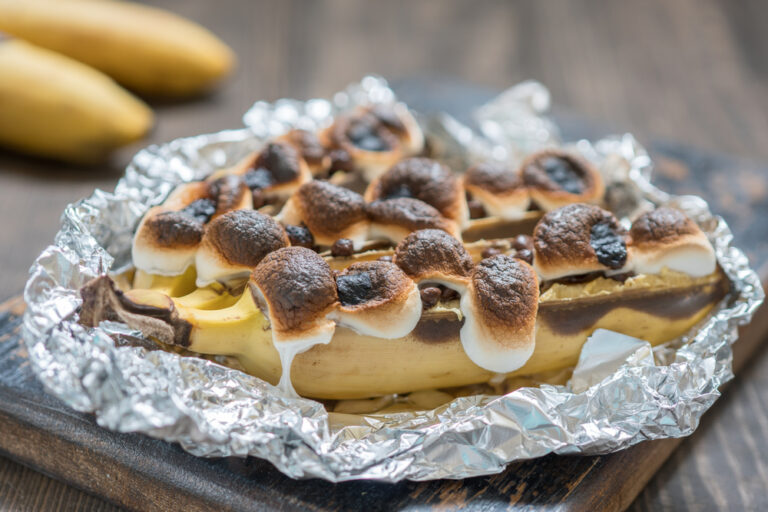 Grilled banana sat in foil with melted marshmallows on top